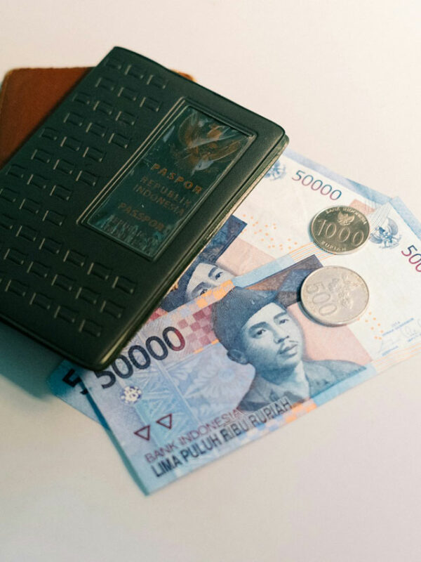 Des billets et pièces de roupie indonésienne avec un passeport indonésien.